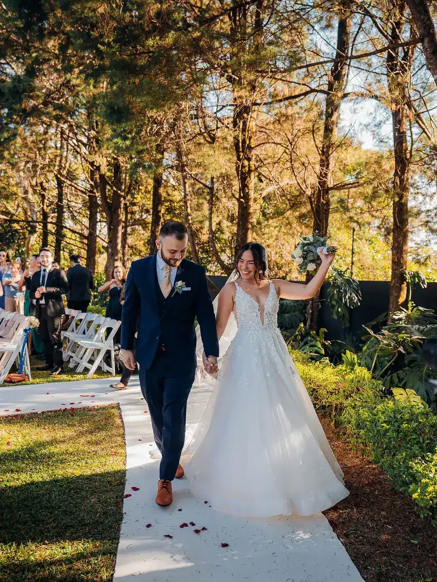 Novios caminando por el sendero del jardín después de la ceremonia en el Gazebo Jardín