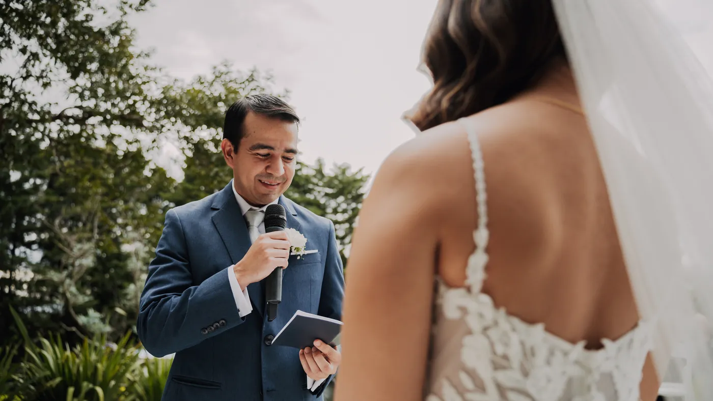 El novio lee sus votos frente a la novia durante una ceremonia en Laureal