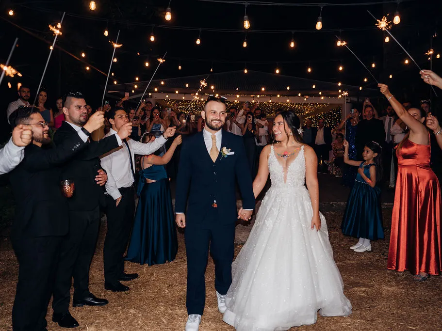 Salida de los novios entre bengalas encendidas al final de la fiesta